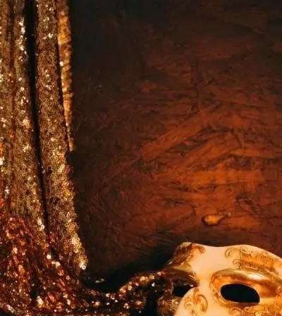 Gold sequin masquerade mask on draped fabric